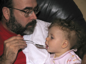 father feeding toddler