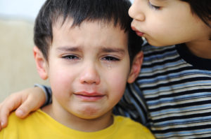 boy comforts crying brother